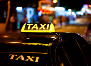 Taxi sign on the roof of a taxi at night